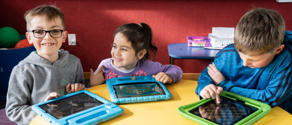 Kids with tablets at a table