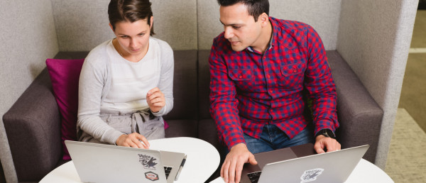 Two people working on laptops together