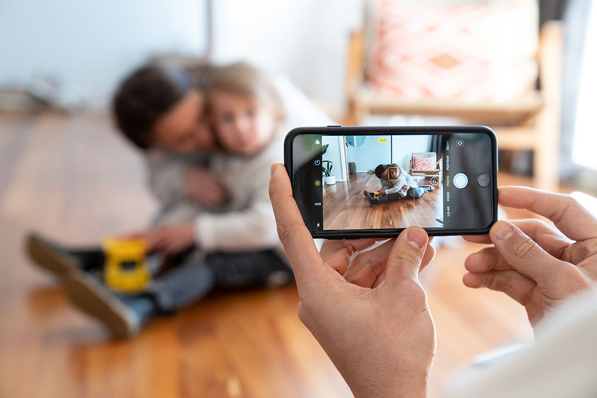 Someone taking a photo with a phone of two people.