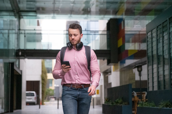 A man walking and looking at a mobile phone