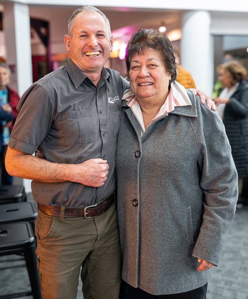 A man and woman standing next to each other and smiling.