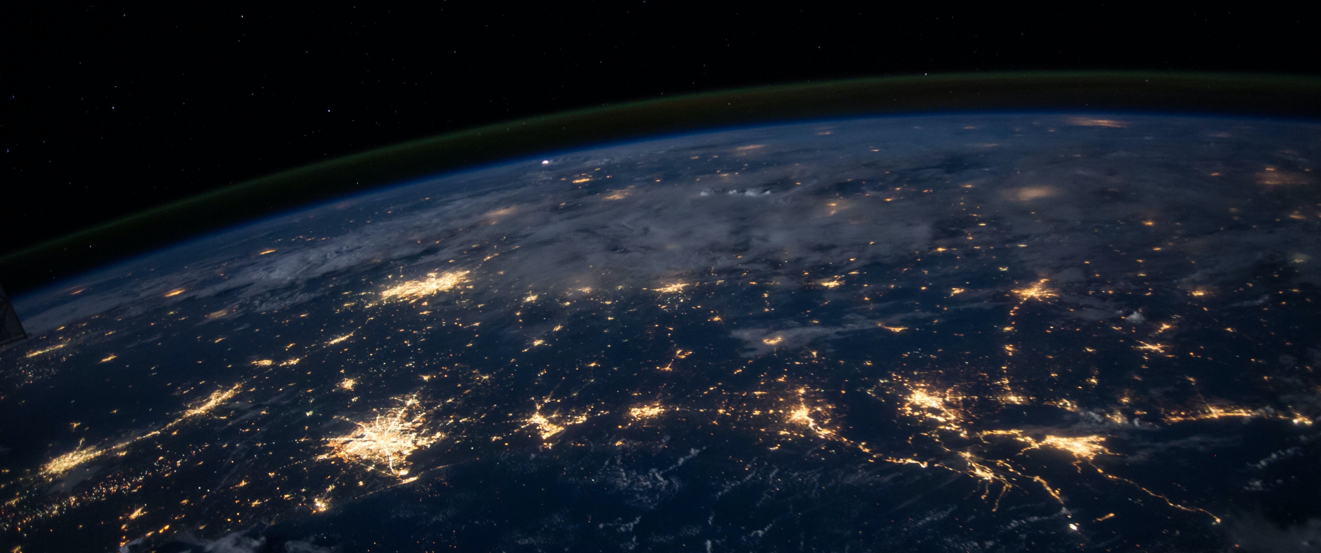 An image of Earth from outer space at night, with glowing areas showing where cities are